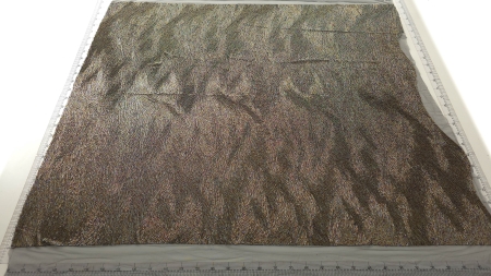 Material multicolor desfășurat pe masă cu mărgele vizibile pe suprafață