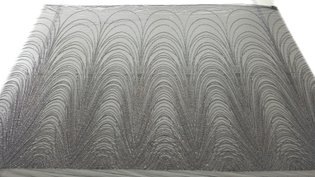 Material negru desfășurat pe masă cu aplicații argintii vizibile