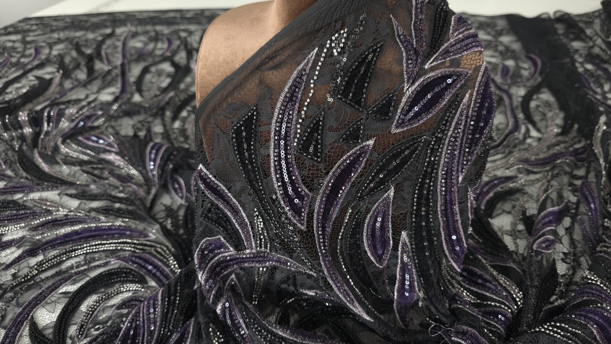 Material pe bust cu spirale bordo negru și margele argintii pe tulle verde