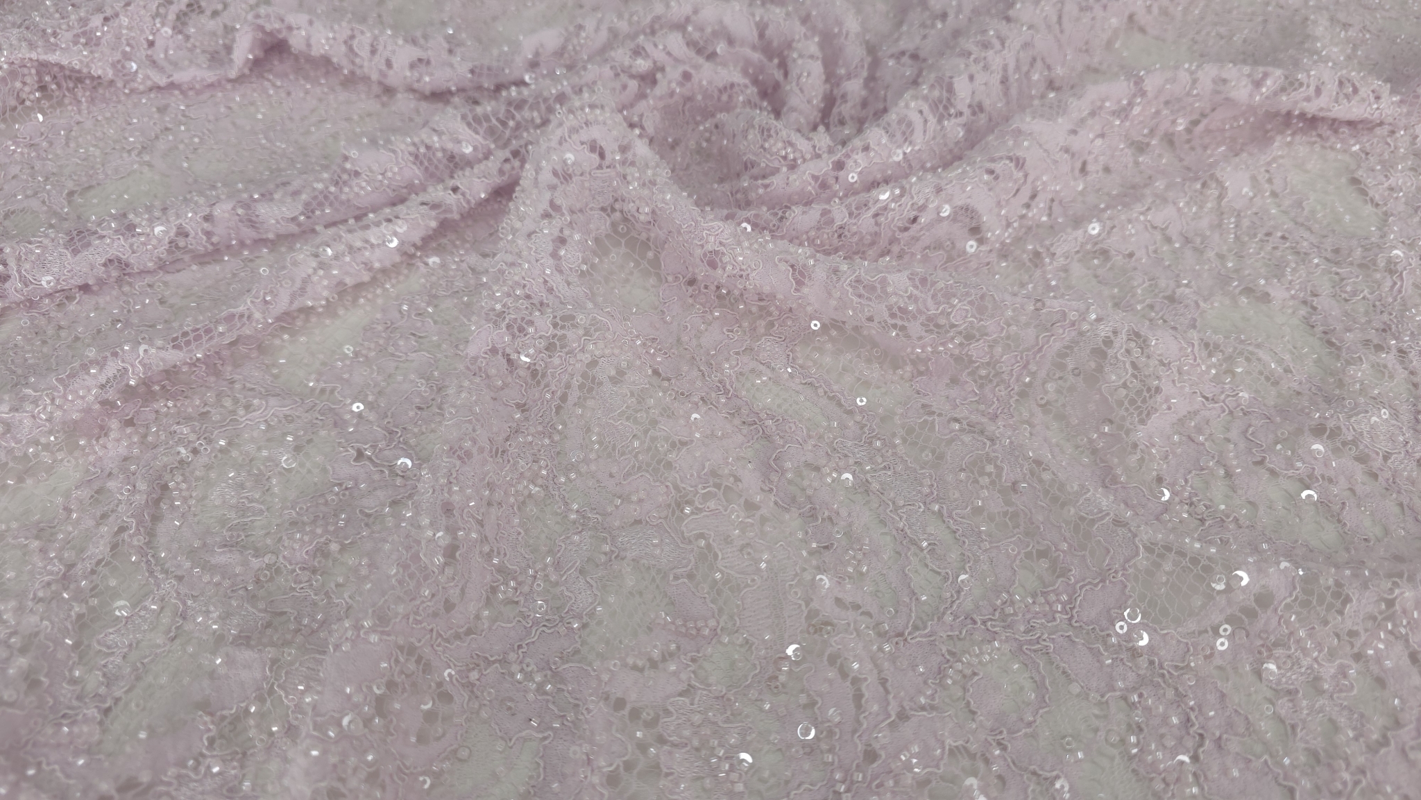 Material roz pastel desfășurat pe suprafață plană cu bordură dublă pe margini