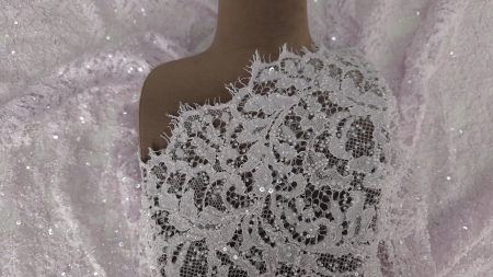 Material drapat pe bustul manechinului, cu conturul scalopat vizibil la decolteu