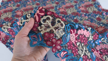 Material ținut în mână pentru a observa broderia densă pe rețeaua neagră