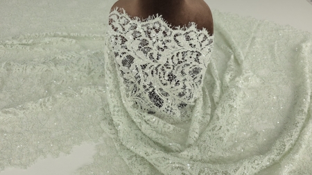 Material verde pastel pe manechin, vedere laterală cu bordură vizibilă