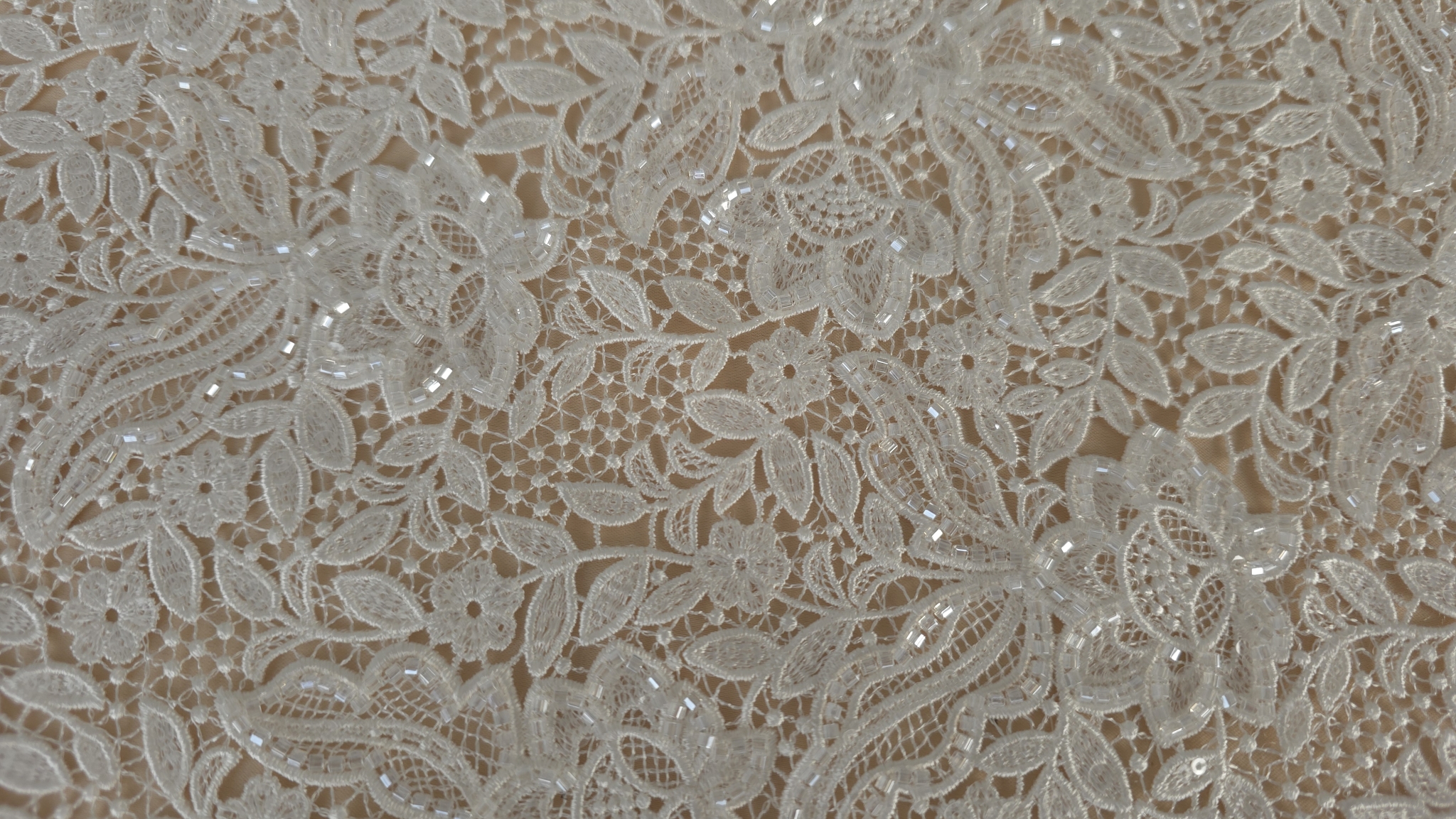 Metraj brodat ivory cu bordură dublă întins pe suprafață plană