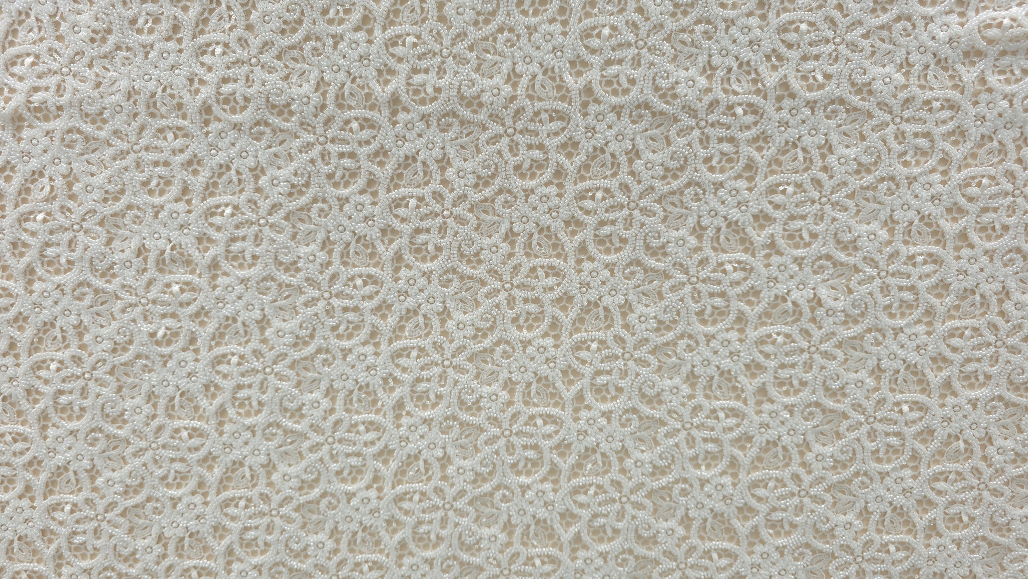 Metraj dantelă ivory pentru rochii de mireasă desfăcut pe masă de lucru