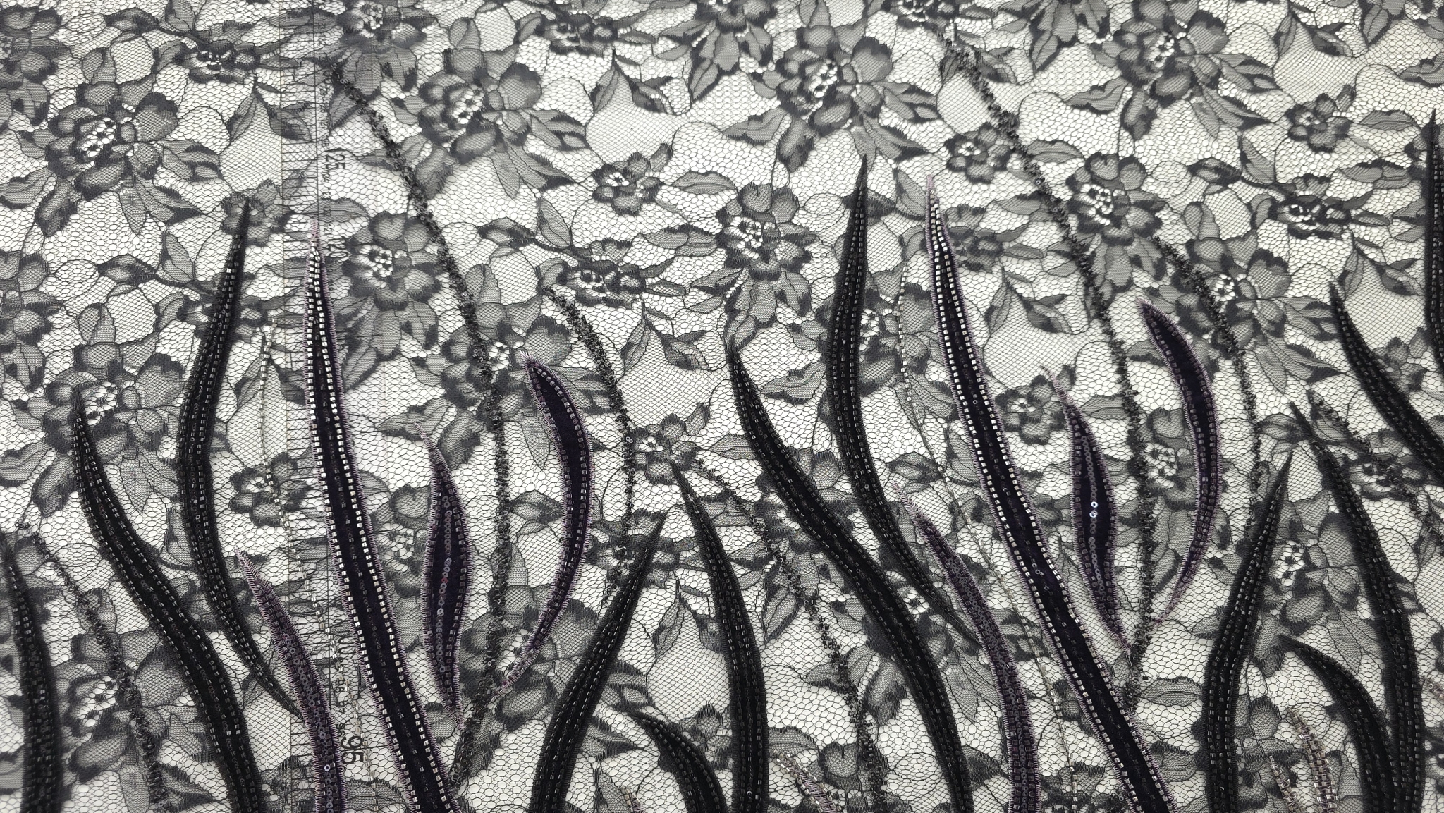 Plan mediu pe spirale și frunze din catifea cu margele argintii pe contur