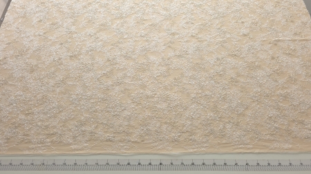 Rolă de material desfăcută pe masă de tăiere cu riglă gradată, vedere de ansamblu