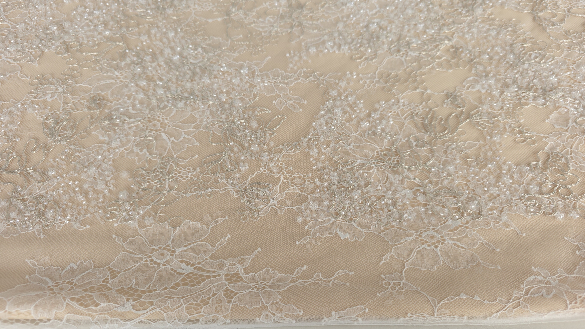 Structură de tul deschis la culoare acoperit cu cusături prețioase