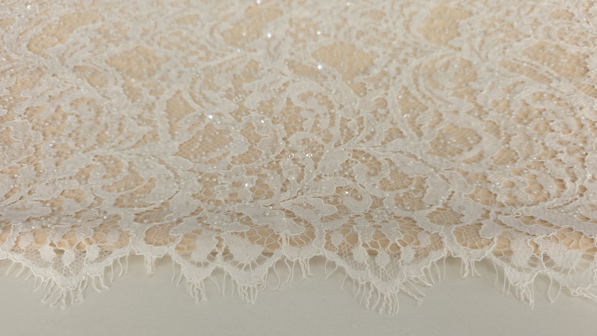 Suprafața dantelei ivory cu micropaiete distribuite pe motivul vegetal