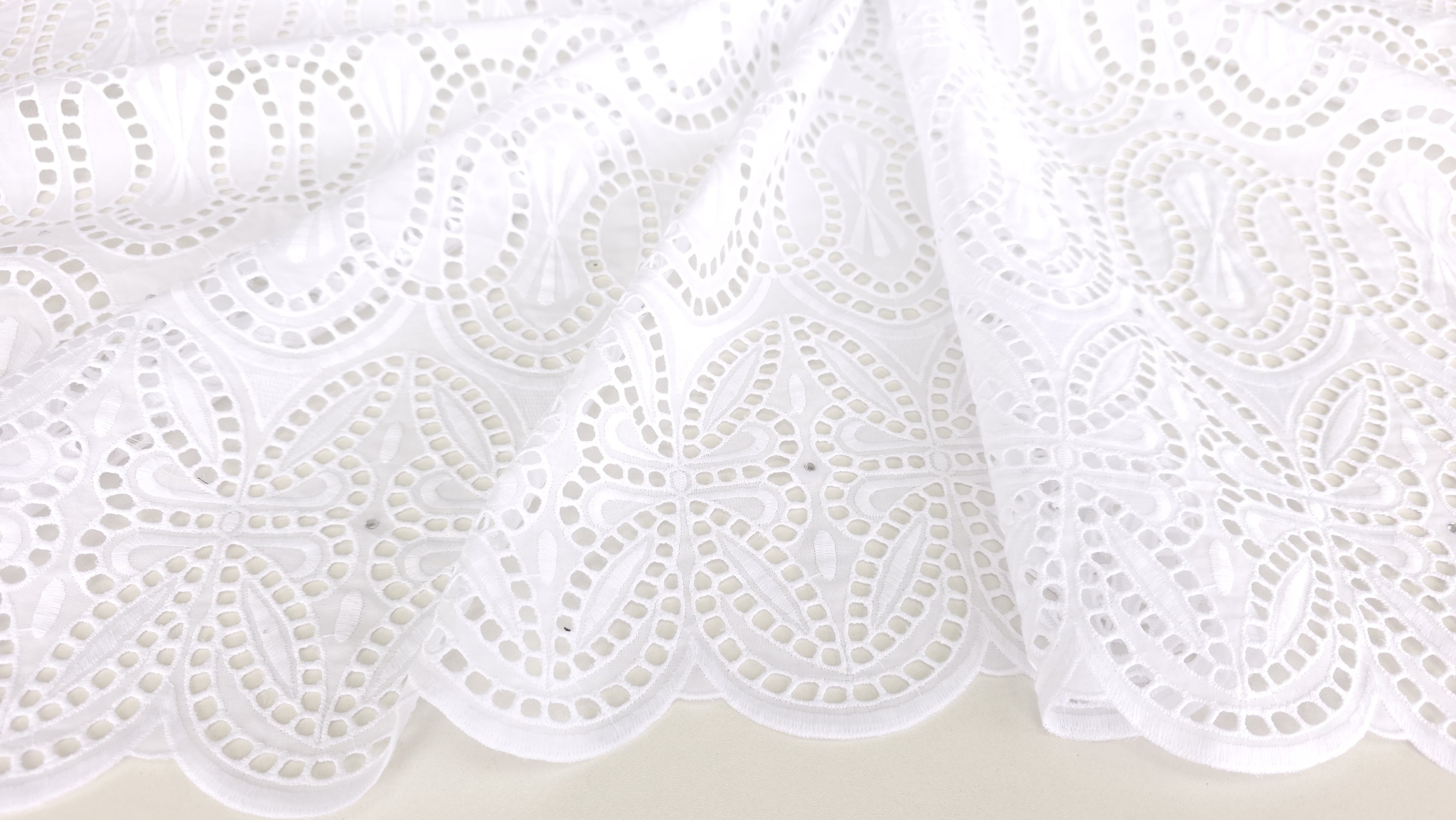 Suprafață de broderie spartă albă cu arcade ovale și motive de legătură între registre