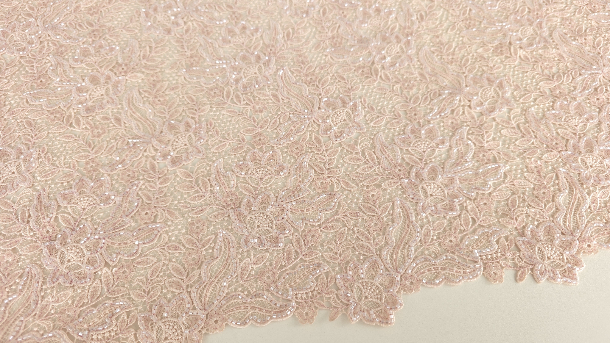 Suprafață textilă cu motive florale dense interconectate pe fond de tul