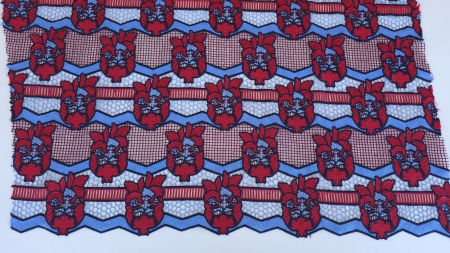 dantela cu bordura rosu albastru asezata pe masa, vedere frontala