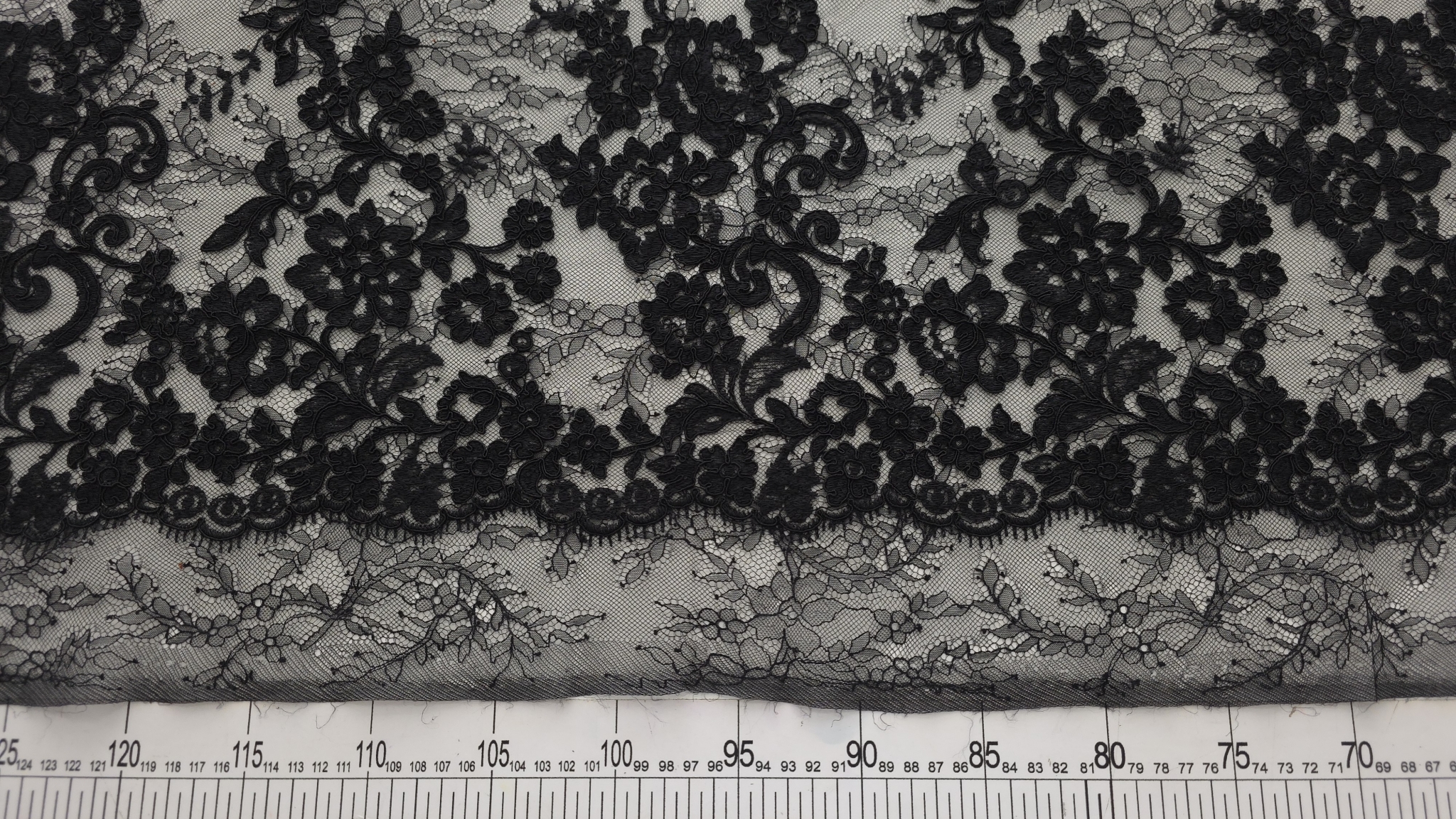 detalii clare cu contururile rebrodate ale florilor așezate pe fundalul de plasă fină