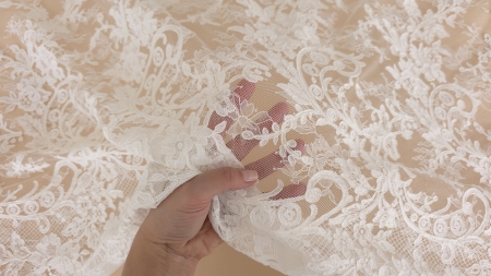 detaliu al ochiurilor fine de tulle care unesc broderia bogată a acestei dantele ivory