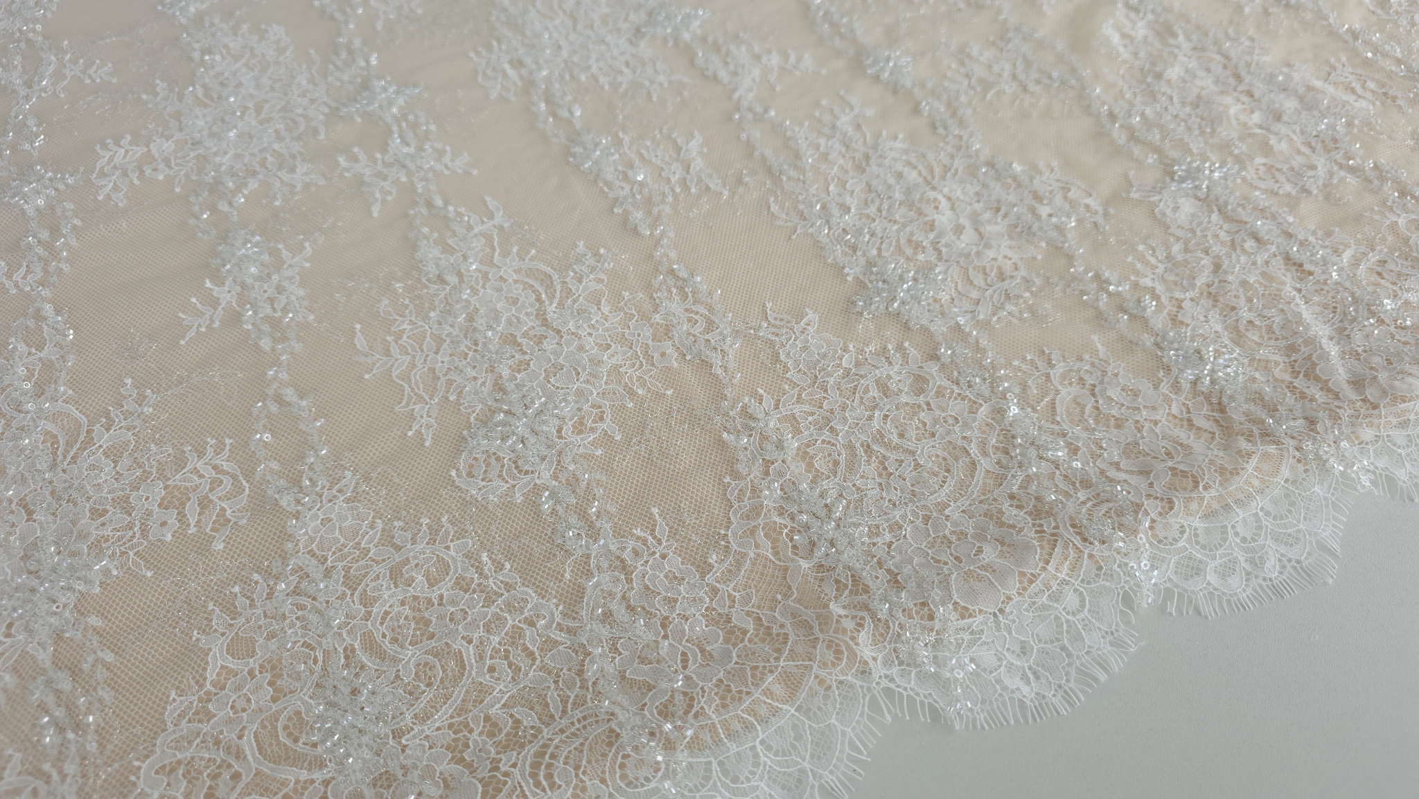 detaliu fir auriu delicat integrat in broderia florala ivory cu micropaiete