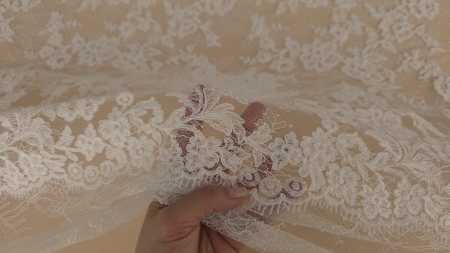 fald natural de dantelă albă, ilustrând căderea fluidă și moale a fibrei de poliamidă