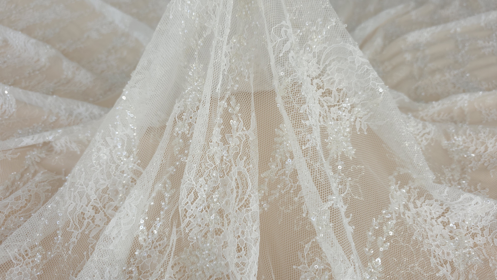 falduri aeriene ale materialului ivory cu micropaiete si fir auriu stralucind tulle transparent vizibil in centru