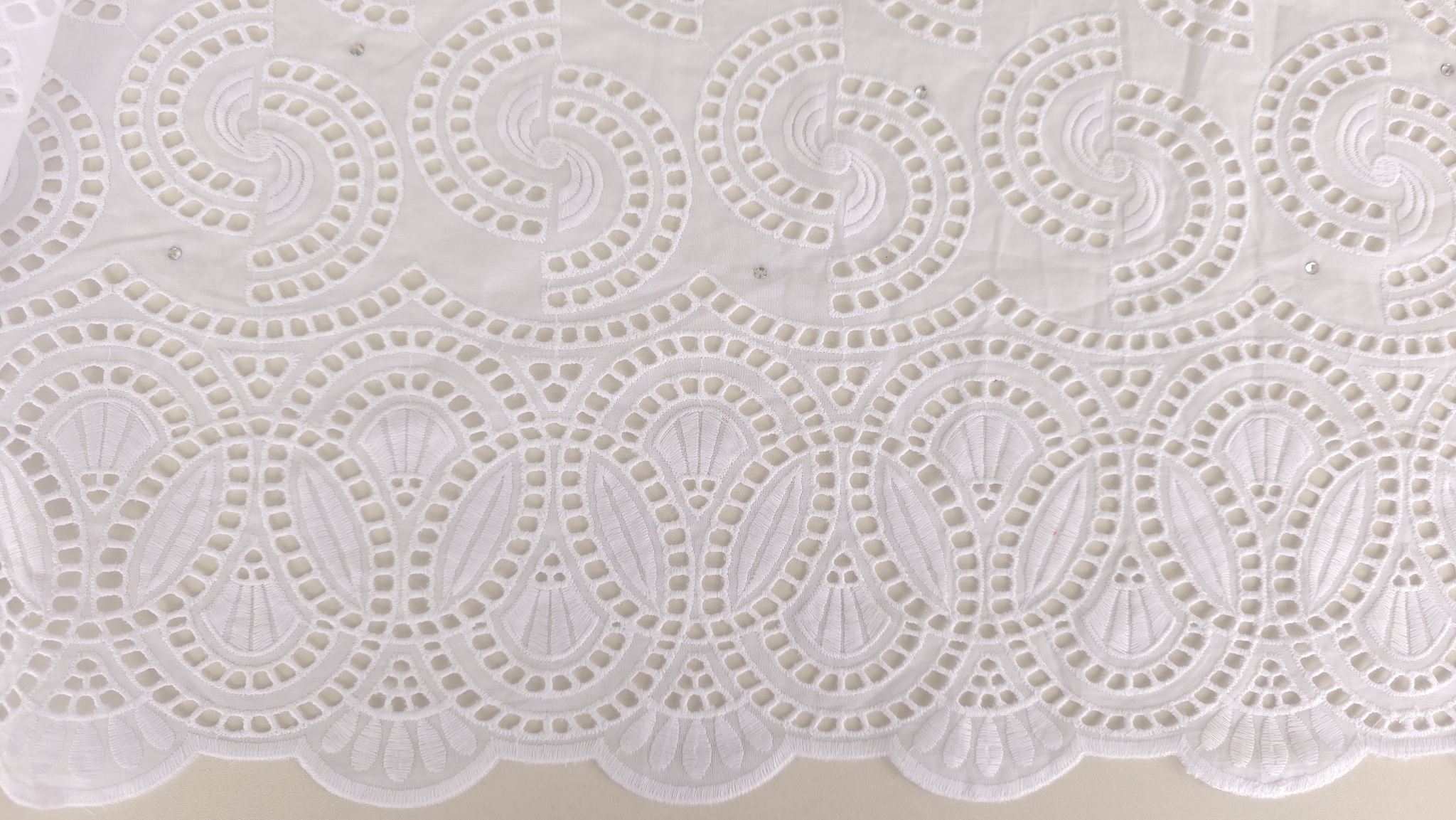 lan apropiat al bordurii inferioare cu contur ondulat și motive ovale brodate în relief