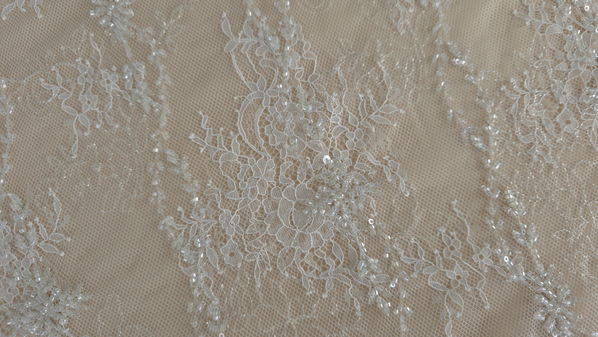 materialul ivory cu accente aurii desfasurat pe bust maro si pe masa bordura festonata vizibila in prim plan