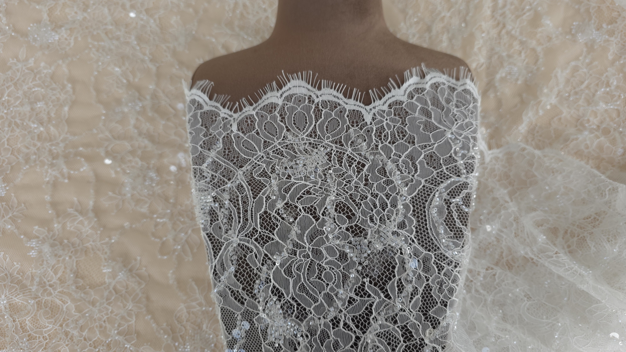 suprafata materialului ivory cu flori ramuri si paiete vazuta la lumina naturala