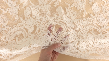 transparența ochiurilor de plasă demonstrată prin trecerea mâinii pe sub materialul dantelat