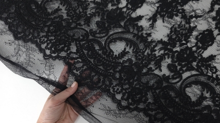 transparența ochiurilor de tulle demonstrată prin poziționarea mâinii sub metrajul negru cu fir reliefat