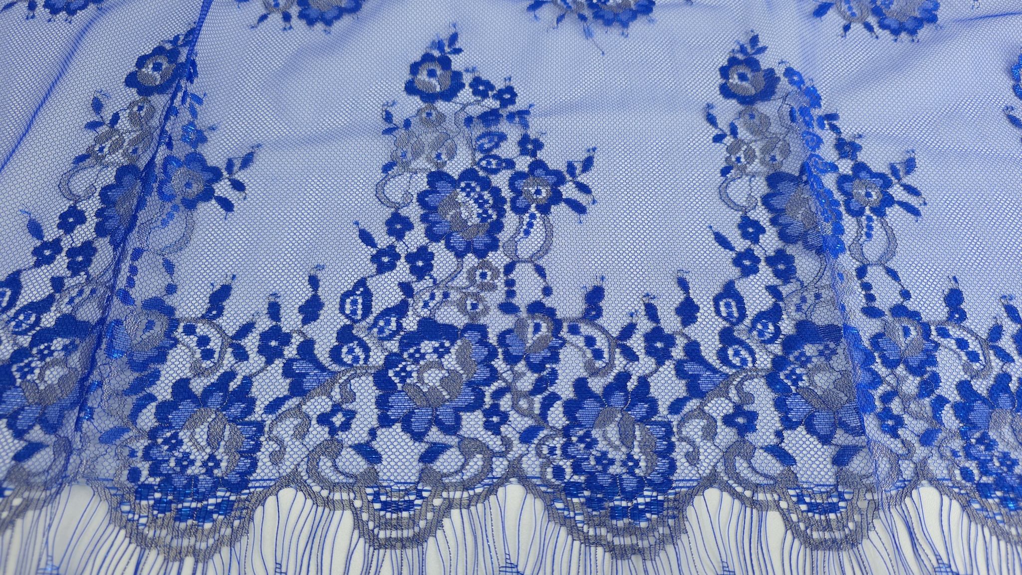 Bordură festonată albastru royal cu inserții argintii metalizate și buchete florale dense pe tull fin transparent