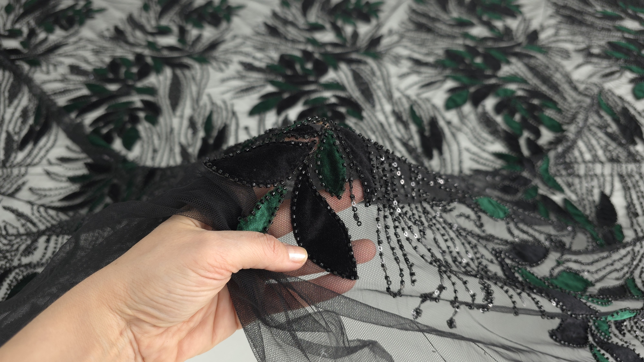 Broderia ținută în mână pentru a evidenția flexibilitatea tullului și detaliile micropaietelor