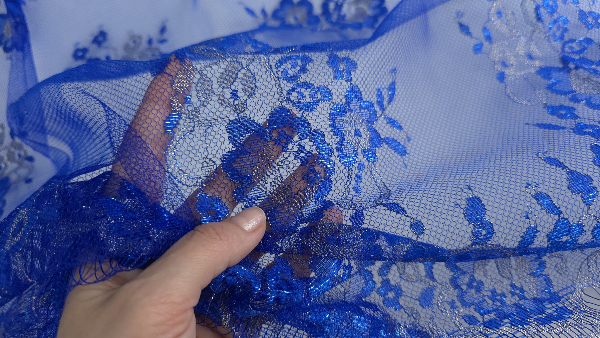 Buchet floral în plan apropiat cu inserții argintii metalizate pe petale și frunze pe tull albastru royal