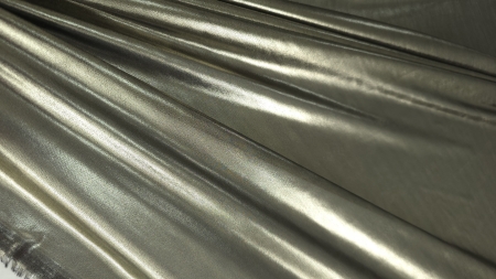 Cădere în falduri diagonale paralele din material metalizat aramă cu reflexii aurii intense și umbre bronz închis