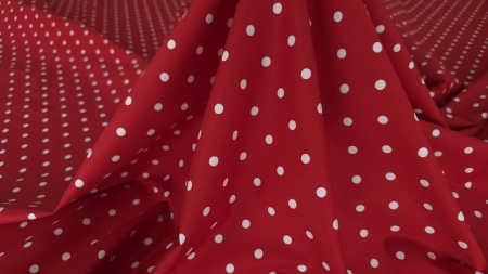 Cădere verticală amplă a materialului cu fald central triunghiular și buline albe care urmează curbura pliurilor
