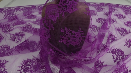 Dantela Chantilly mov orhidee drapată pe manechin maro cu buchete florale și tull transparent pe bust