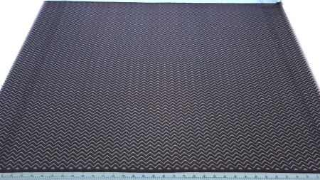 Dantelă neagră cu fir metalizat roșu model zigzag întinsă pe masă cu riglă de măsurare