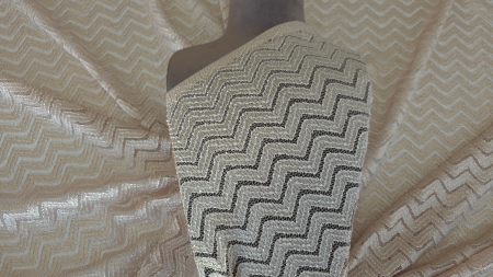 Dantelă nude cu fir metalizat model zigzag prezentată pe bust de manechin