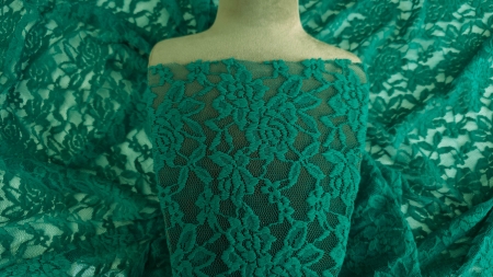 Dantelă tip chantilly rebrodată verde pe bust de prezentare, model floral vizibil