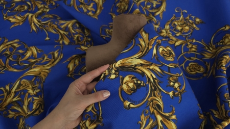 Denim elastic drapat pe manechin maro, cădere fermă cu ornamente aurii