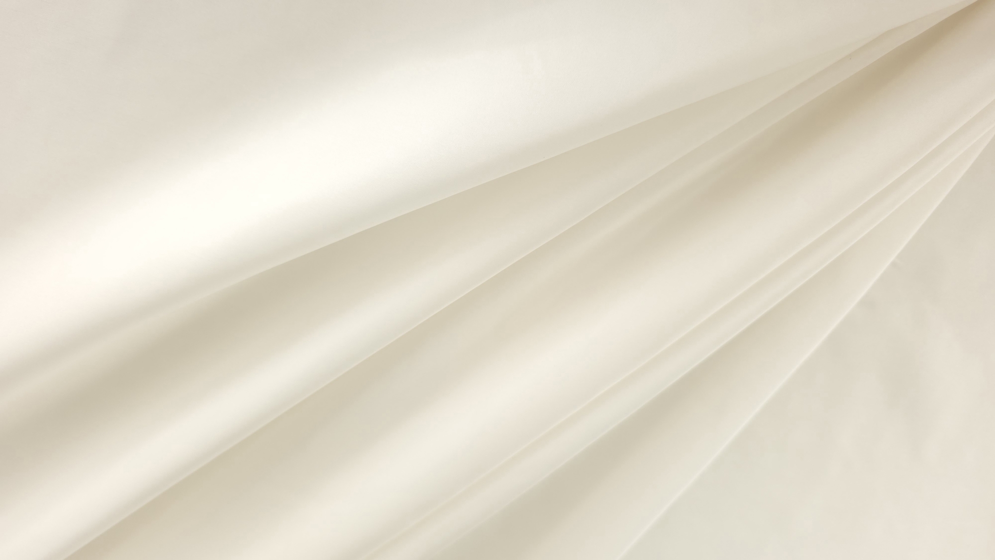 Detaliu de textură netedă și luciu delicat pe suprafața căptușelii satinate ivory din mătase