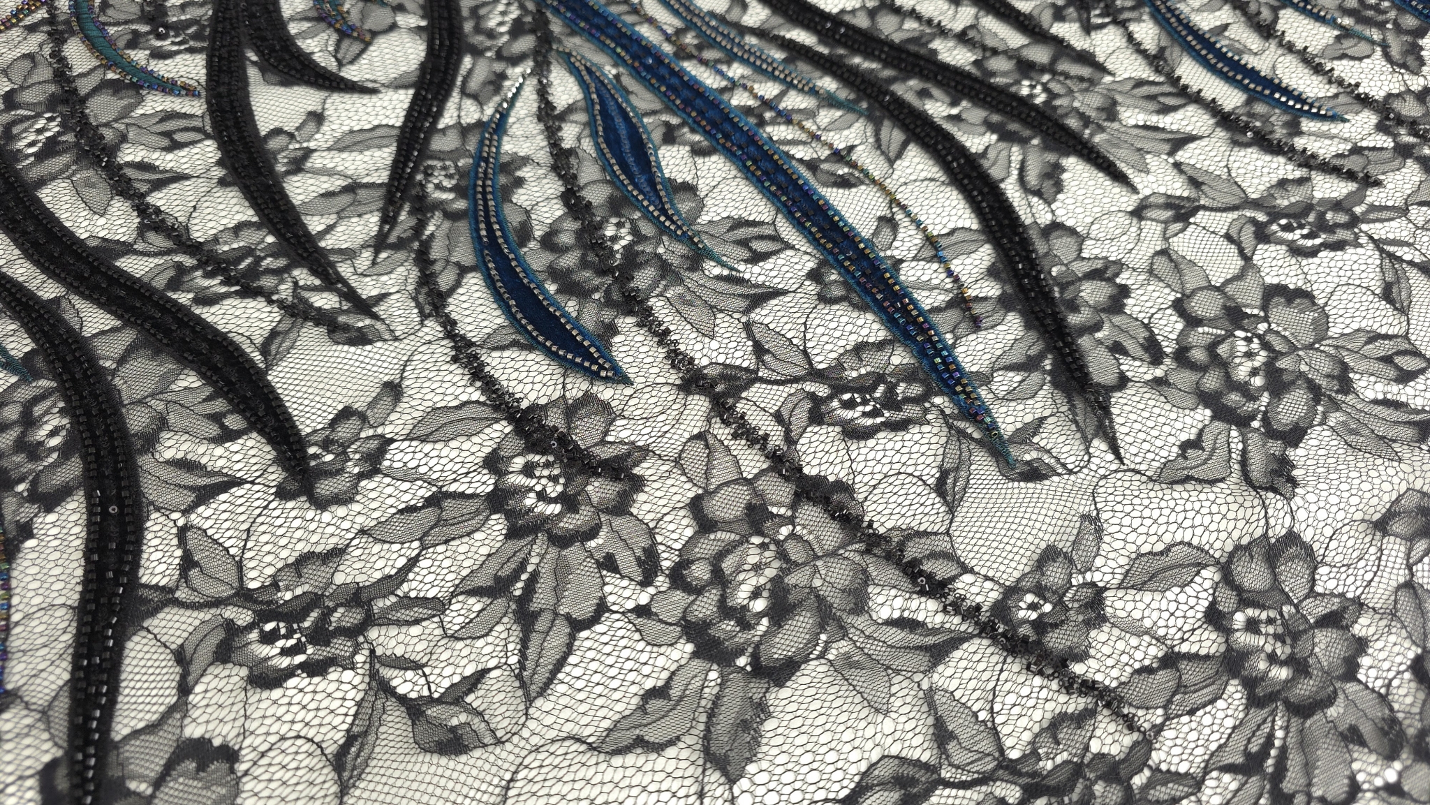 Detaliu margele multicolore pe catifea turcoaz și margele argintii pe catifea neagră