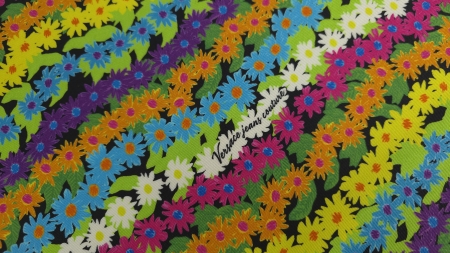 Detaliu pe diagonală al imprimeului floral multicolor cu semnătura Versace jeans couture pe fundal negru