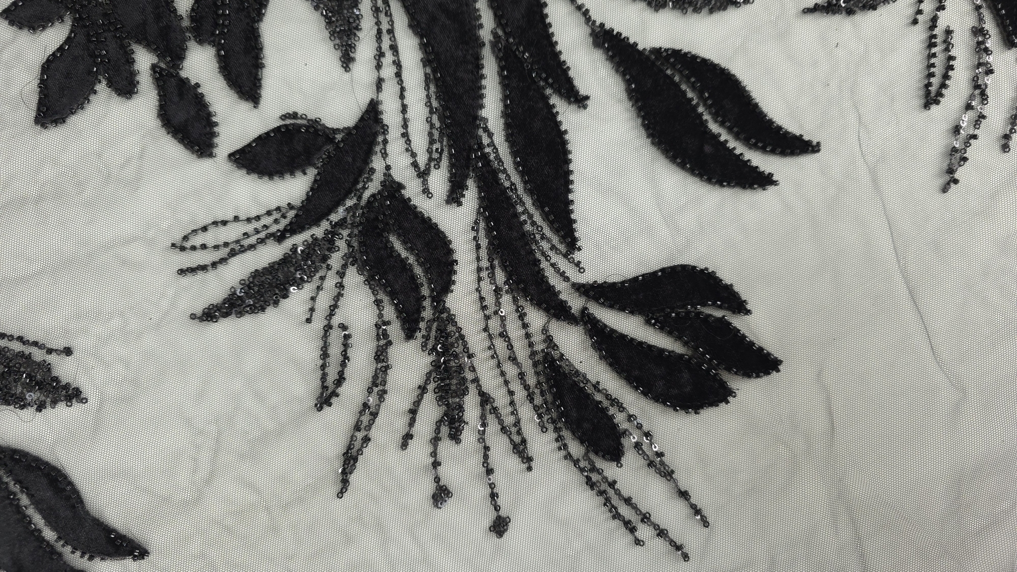 Detaliu plan apropiat al margelelor ce conturează petalele florale negre