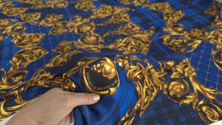 Detaliu textură fină cu volute aurii pe fond bleumarin