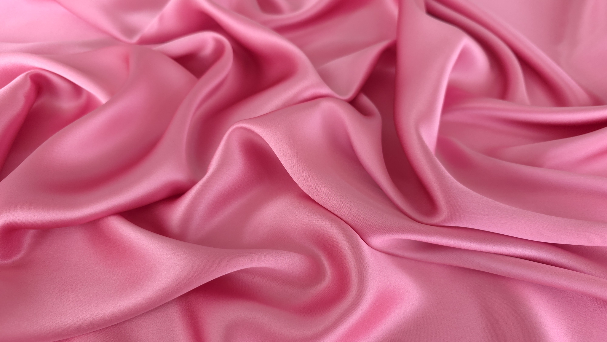 Falduri fluide de material roz luminos cu luciu satinat vizibil
