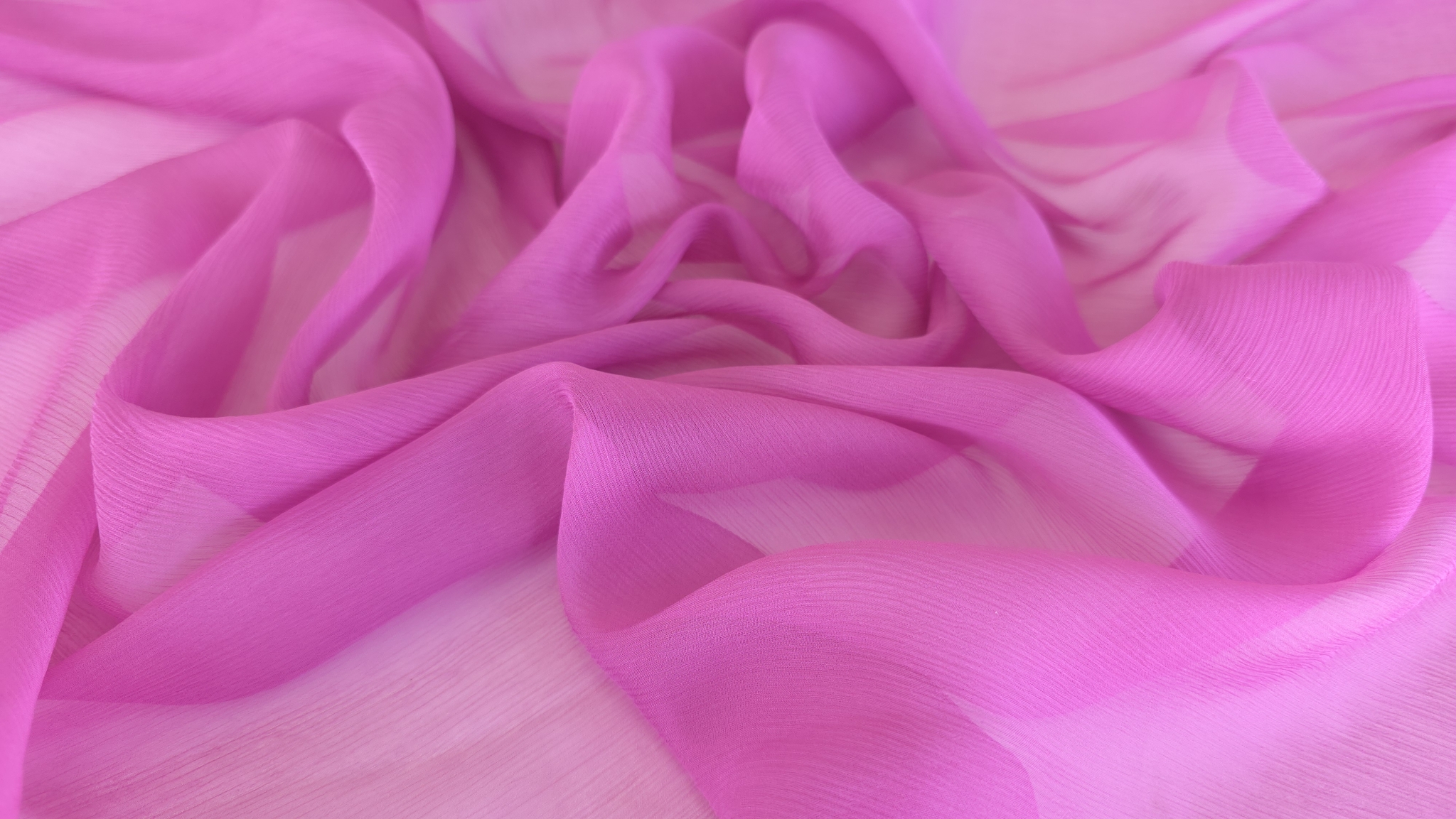 Falduri ample de muselină de mătase naturală roz intens creponată aranjate pe fundal alb