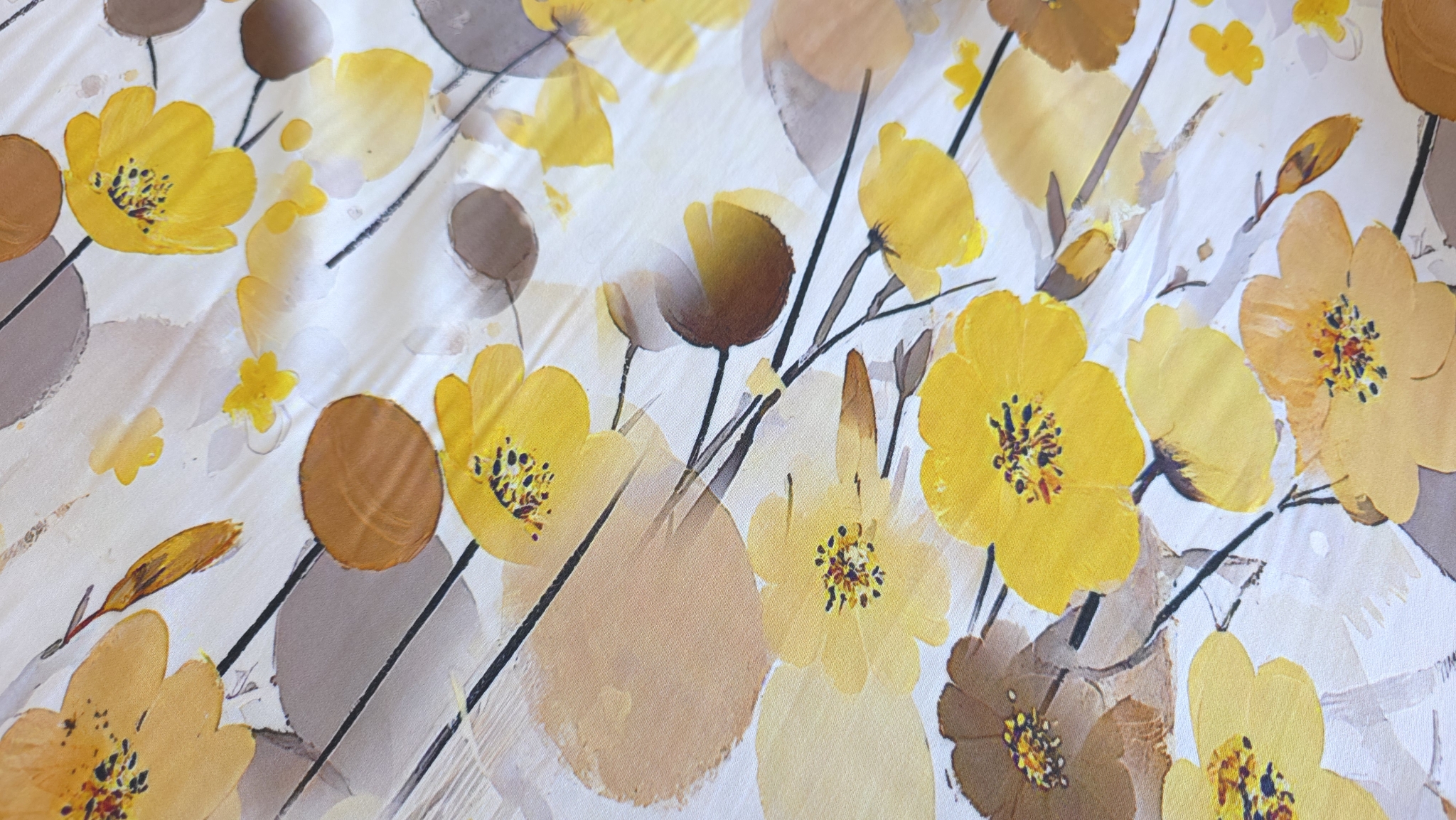 Flori galbene și ocru cu frunze bej-caramel pe suprafață albă în plan apropiat oblic