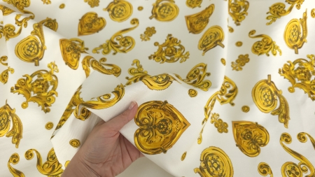 Mâini ținând un pătrat de material cu inimă aurie centrală