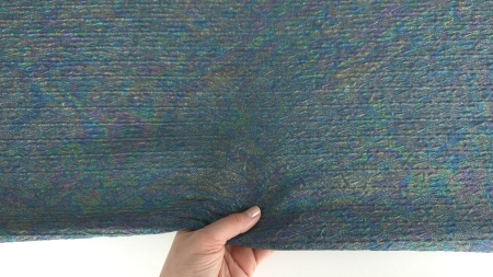 Mână care ridică margine de material textură fluidă și opacitate vizibilă