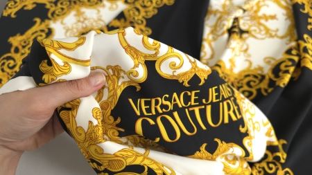 Mână strângând crepul elastic cu imprimeu baroc pentru verificarea texturii