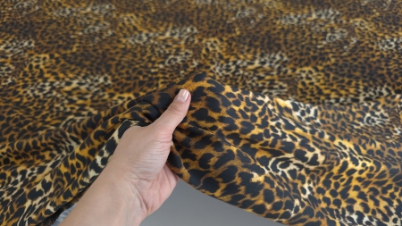 Satin elastic cu print leopard strâns ușor în mână pentru a evidenția textura fină
