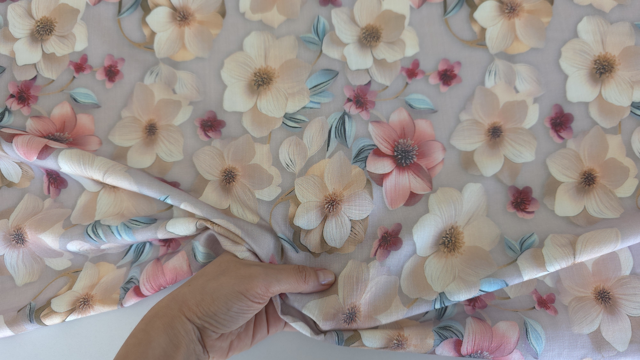Mână strângând ușor vâscoza florală mauve gray pentru a arăta textura fină și flexibilitatea materialului sidefat