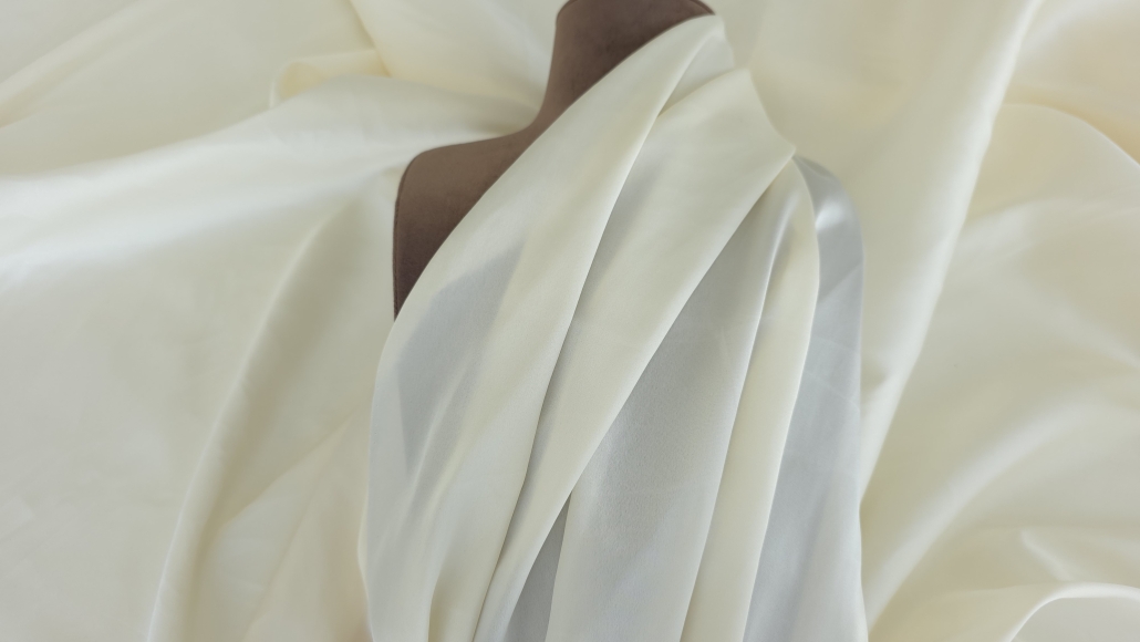 Manechin de croitorie cu un drapaj din mătase ivoire, prezentând căderea naturală și modul în care materialul se așază în cute asimetrice